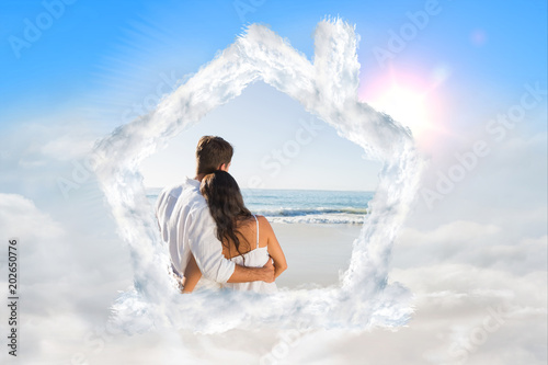 Content couple looking at the waves against blue sky with white clouds