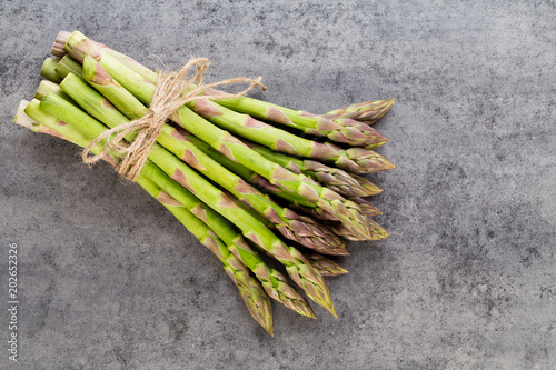 Bunch of fresh asparagus on wooden table.