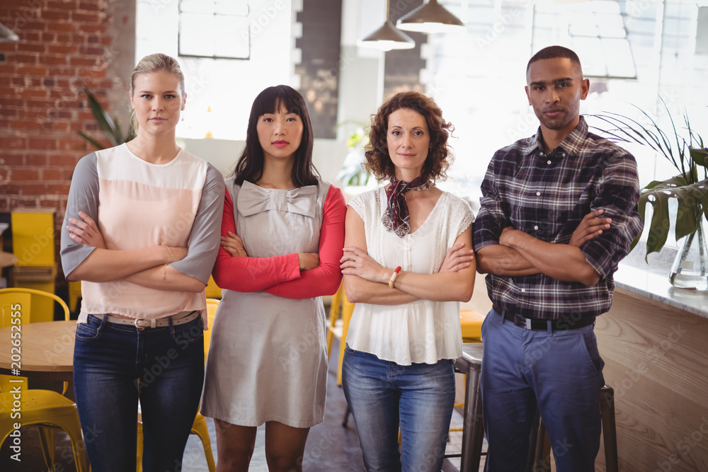 Confident young friends standing with arms crossed