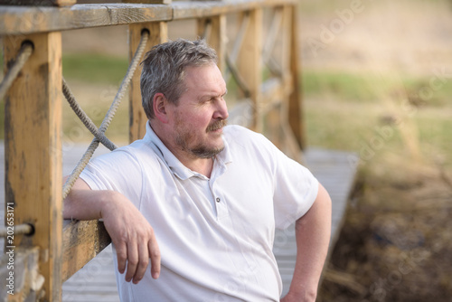 handsome man looks thoughtfully into the distance in the summer outdoors