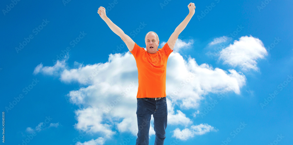 Mature man in orange tshirt cheering against cloudy sky Mature man in orange tshirt cheering against cloudy sky