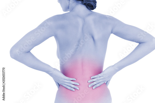 Rear view of a fit topless young woman with back pain standing over white background