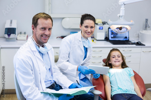 Portrait of smiling dentists and young patient