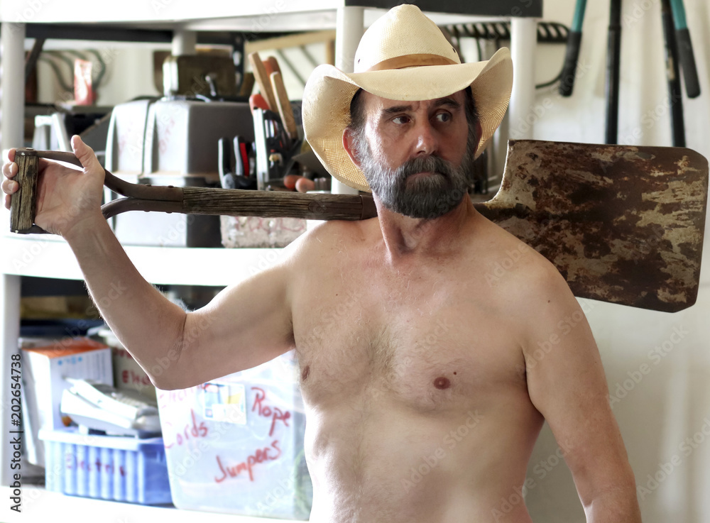 Fotografie A Bearded Cowboy Puttering in His Tool Shed