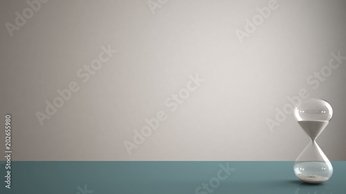 Blue pantone table, desk or shelf with crystal modern hourglass measuring the passing time in a countdown to a deadline, white copy space background