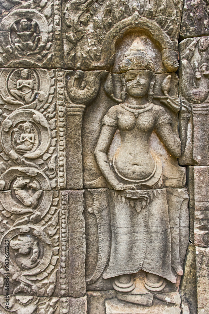 Khmer devata guardian shown in stone in Ta Prohm temple, in Angkor, Siem Reap, Cambodia.