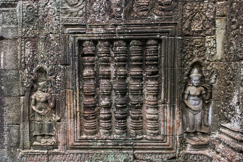 Khmer devata guardian shown in stone in Ta Prohm temple, in Angkor, Siem Reap, Cambodia. photo