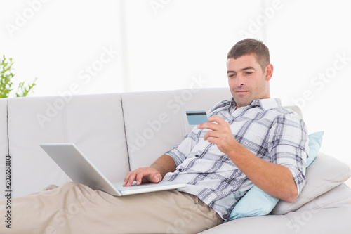 Man shopping online through laptop using credit card