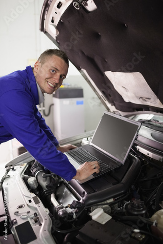 Smiling mechanic working on a computer