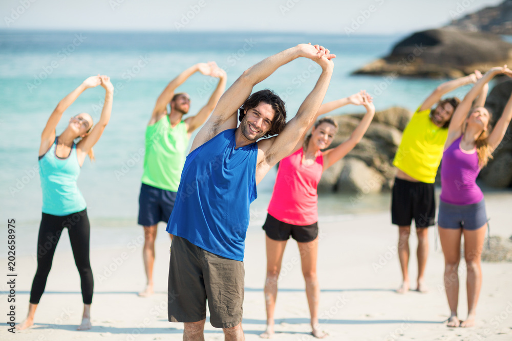 Obraz premium Friends exercising while standing on shore