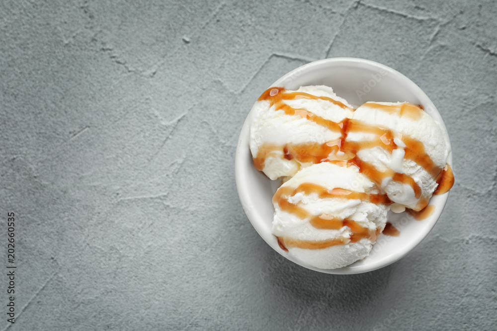 Tasty ice cream with caramel sauce in bowl on table Tasty ice cream with caramel sauce in bowl on table