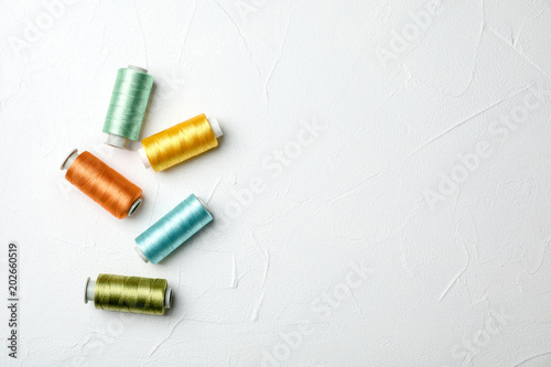 Color sewing threads on light background, top view