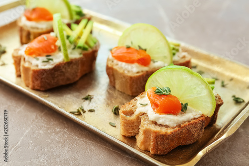Sandwiches with fresh sliced salmon fillet and avocado on tray