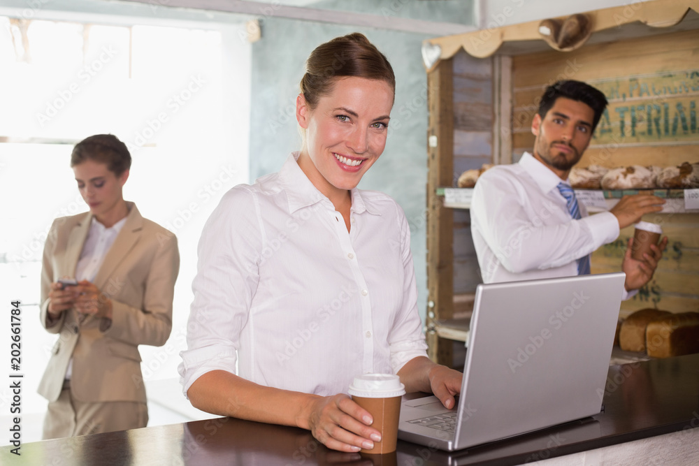 Businesswoman using laptop in office cafeteria