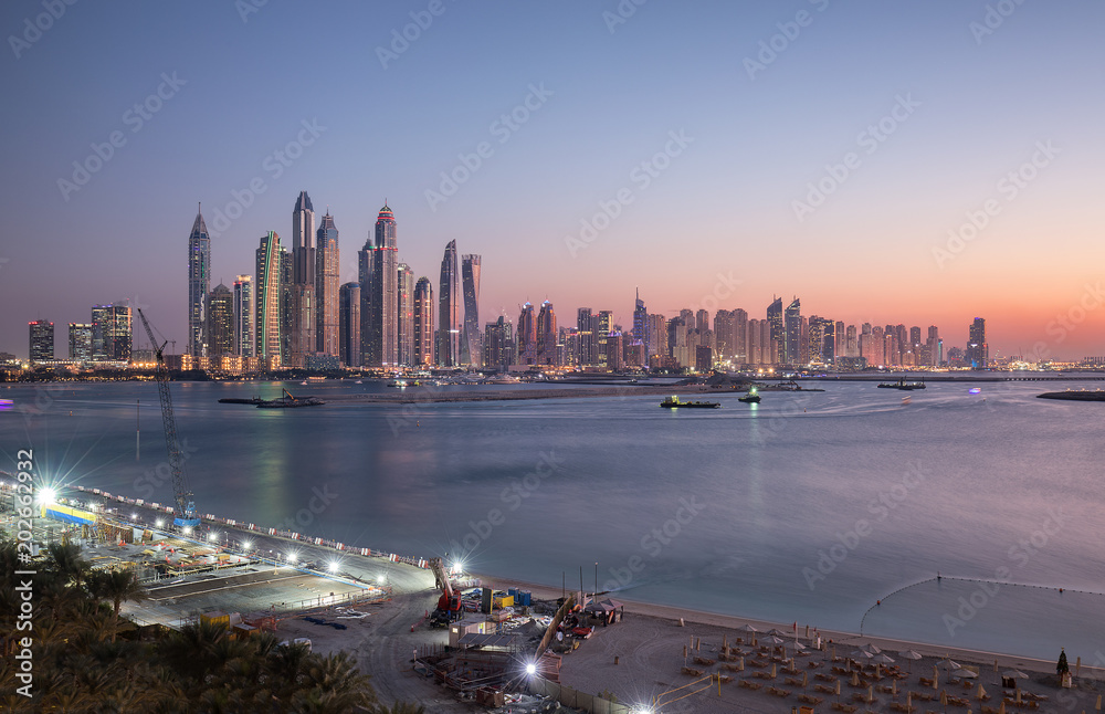 Fototapeta premium Skyline of Dubai Marina at sunset with a beautiful beach in the foreground