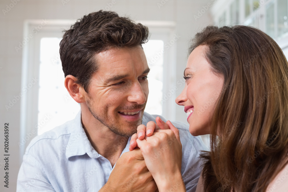 Loving young couple holding hands at home Loving young couple holding hands at home