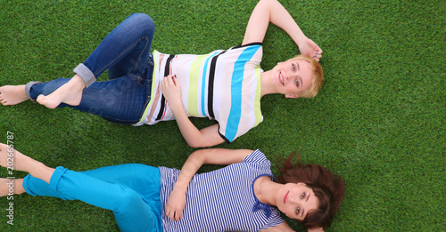 Young women lying on green grass . Young women