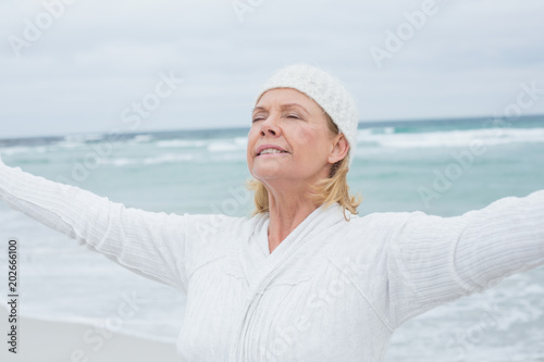 Senior woman with arms outstretched at beach © WavebreakmediaMicro