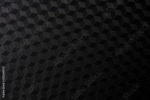 Close up isometric seamless render of hexagon design background seems like 3D cubes shapes mosaic. Creative dark tones black square texture photography illuminated to reach three dimensional effect.