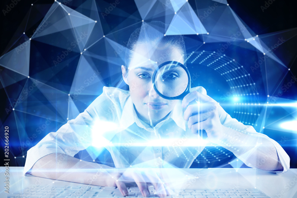 Φωτογραφία Businesswoman typing and looking through magnifying glass against blue technolog