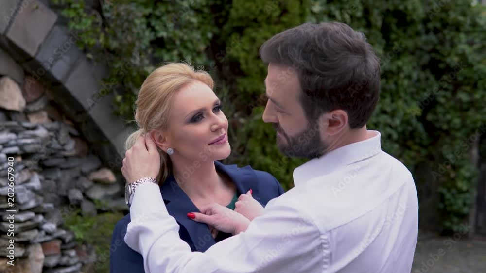 The man pats the woman's face, straightens the hair. A loving couple is looking at each other's face. Sincere feelings of love. The man pats the woman's face, straightens the hair. A loving couple is looking at each other's face. Sincere feelings of love.