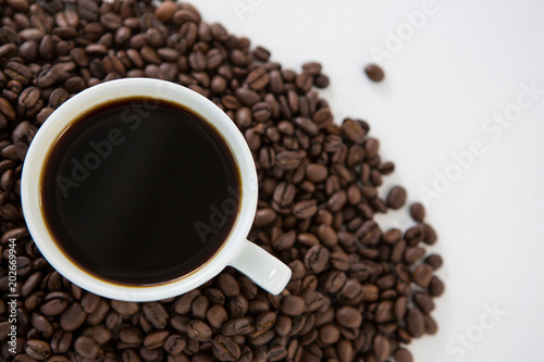 Cup of black coffee with roasted coffee beans