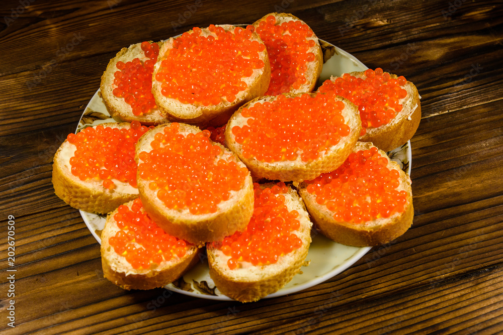 Sandwiches with red caviar on wooden table. Top view Sandwiches with red caviar on wooden table. Top view