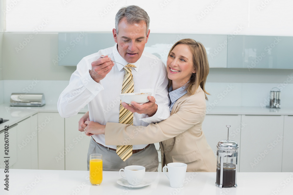 Woman embracing man while having breakfast in kitchen Woman embracing man while having breakfast in kitchen