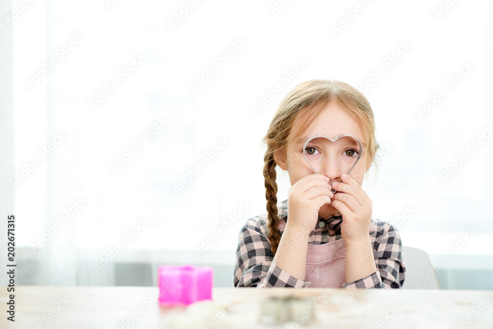 Φωτογραφία Portrait shot of cute little girl wearing checked shirt looking at camera throug