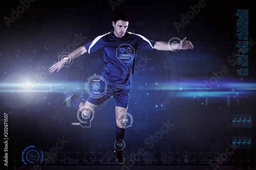 Football player in blue kicking against blue dots on black background © vectorfusionart