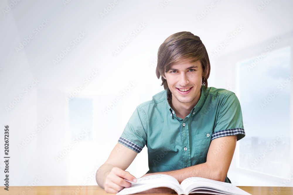 Student sitting in library reading  against bright white hall with columns
