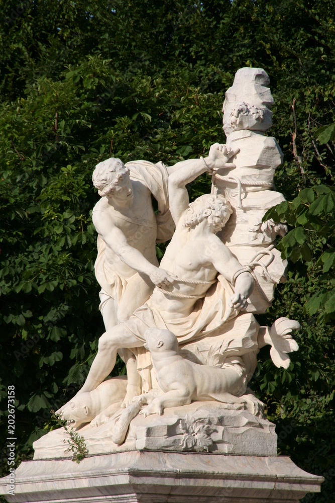 White marble sculpture of the man hanging with rope anothe man in bright sunny summer day in Versailles garden