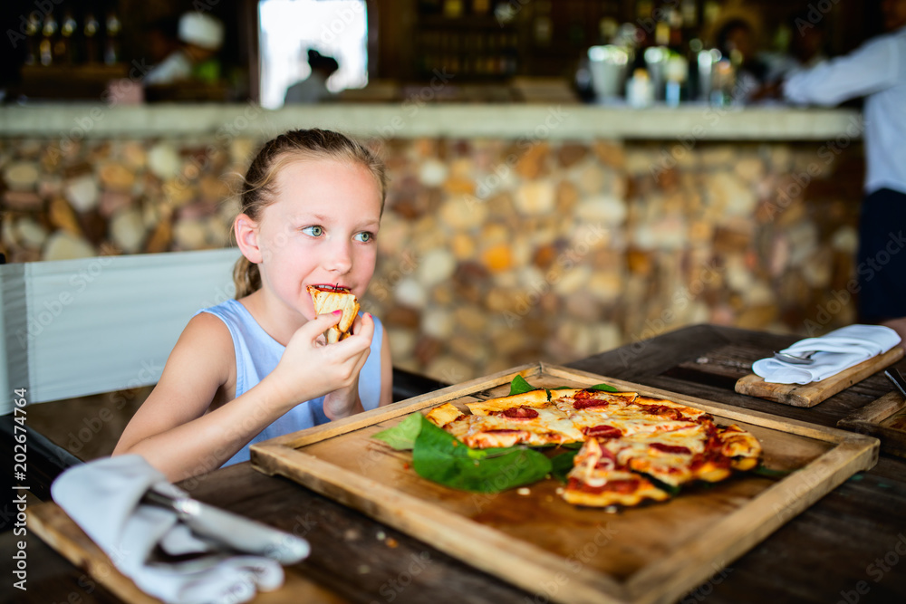 Little girl eating pizza