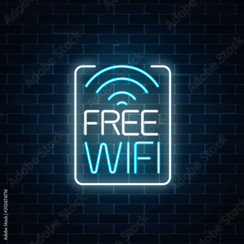 Neon sign of free wifi zone in rectangle frame on dark brick wall background. Wireless connection free access in cafe.