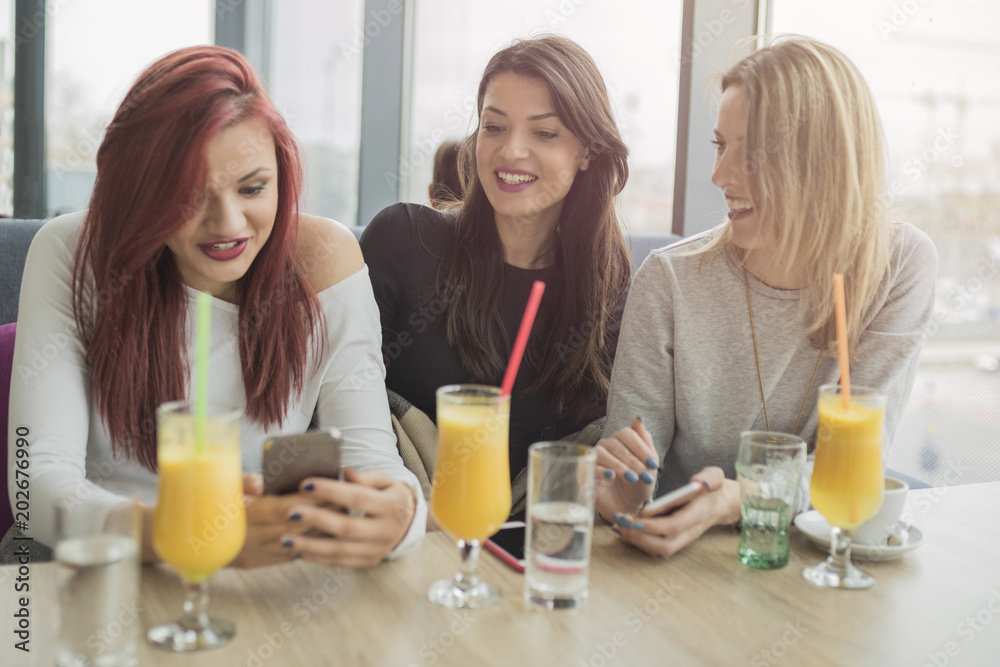 Portrait of three young beautiful women using mobile phone at coffee shop. Portrait of three young beautiful women using mobile phone at coffee shop.