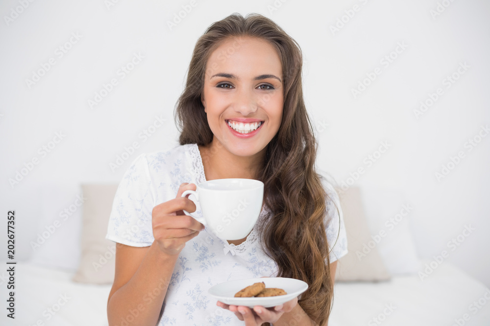 Cheerful attractive brunette holding a cup