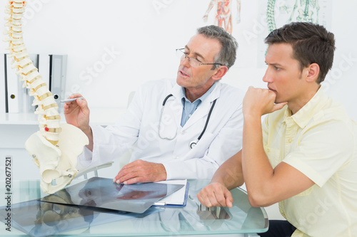 Doctor explaining spine to a patient in office