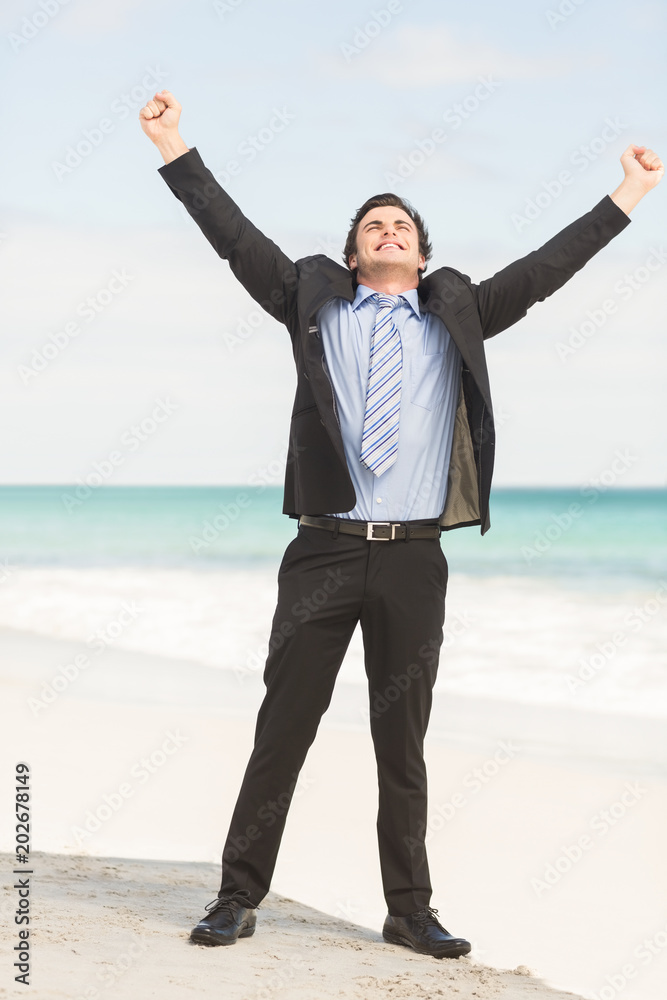 Happy businessman cheering at the beach Happy businessman cheering at the beach