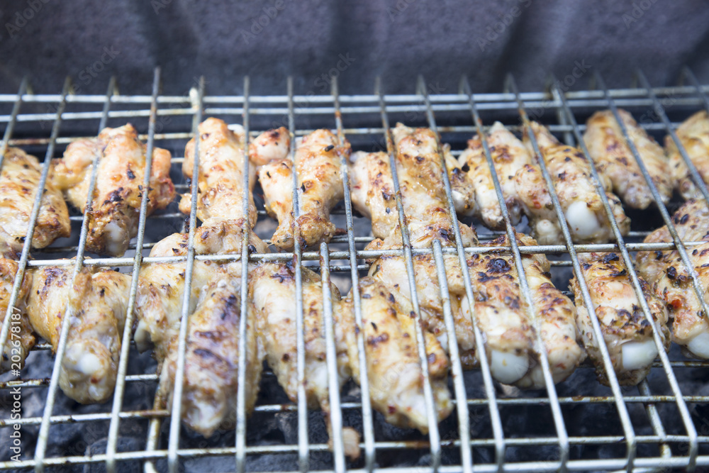 Chicken meat wings that turn over on a barbecue grill.Meat is fried in Mangal Barbecue grill. Chicken meat on the gril 