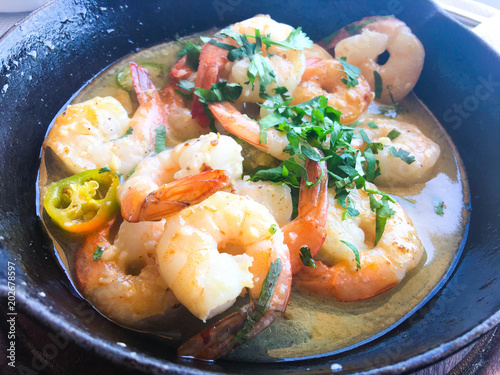 Shrimp in a creamy garlic sauce with parsley in a frying pan
