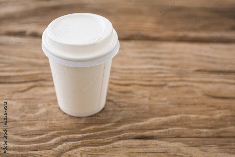 Disposable coffee cup on wooden background Disposable coffee cup on wooden background
