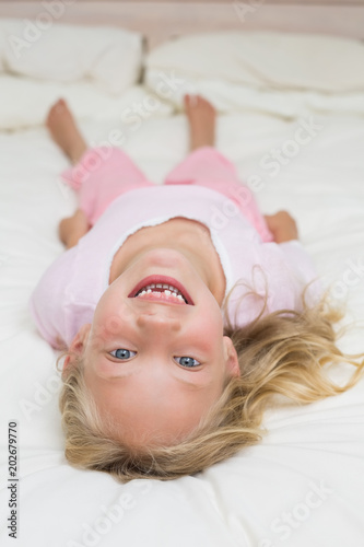 Portrait of a happy girl lying in bed