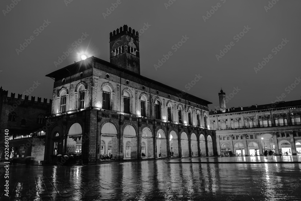 King Enzo palace at the main square of Bologna, Italy. Famous landmark at sunset at night. Black and white
