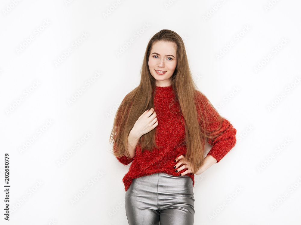 Spectacular blonde woman in red blouse silver leather pants posing in front of white wall. Graceful girl gorgeous long hair having fun on photoshoot. Spectacular blonde woman in red blouse silver leather pants posing in front of white wall. Graceful girl gorgeous long hair having fun on photoshoot.
