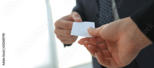 Close-up of two businesspeople exchanging visiting card