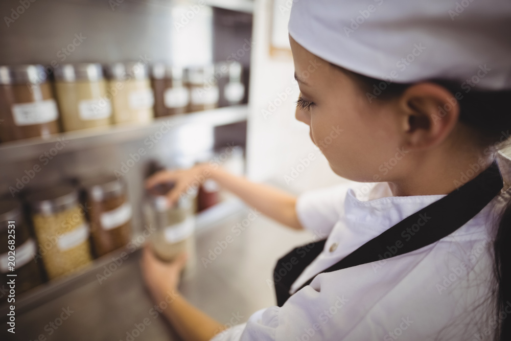 Ταπετσαρία Female chef selecting a spice jar in the commercial kitchen