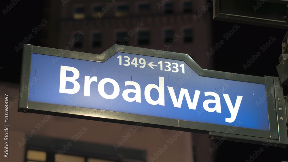 CLOSE UP: Blue Broadway road sign with numbers at street corner in New York CLOSE UP: Blue Broadway road sign with numbers at street corner in New York