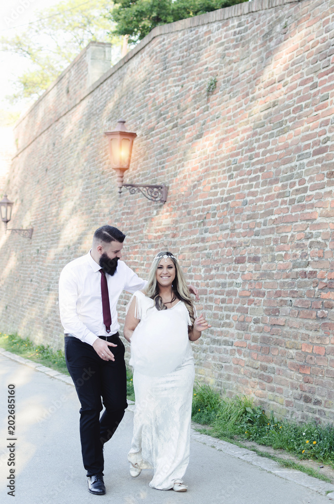 wedding couple walking on european streets , have fun and hugging with sugar foam wedding couple walking on european streets , have fun and hugging with sugar foam