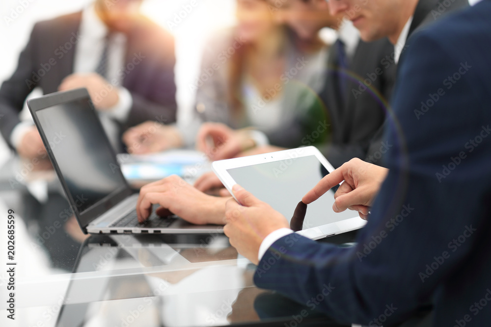 Business man using a tablet while business people talking in th Business man using a tablet while business people talking in th