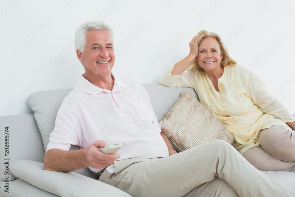 Senior couple with remote control at home
